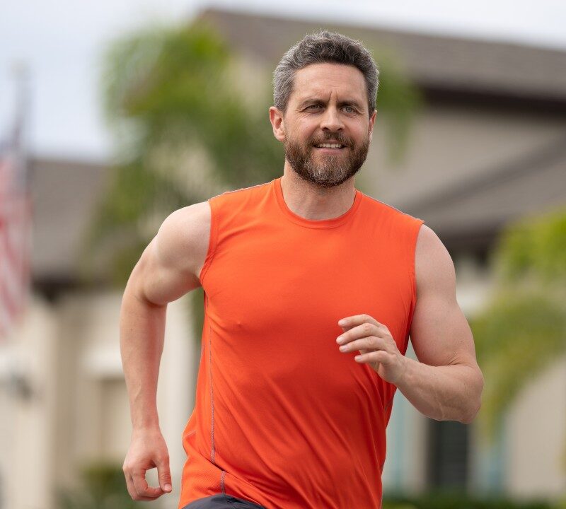 Hombre corriendo al aire libre para reducir el colesterol LDL con ejercicio intenso.