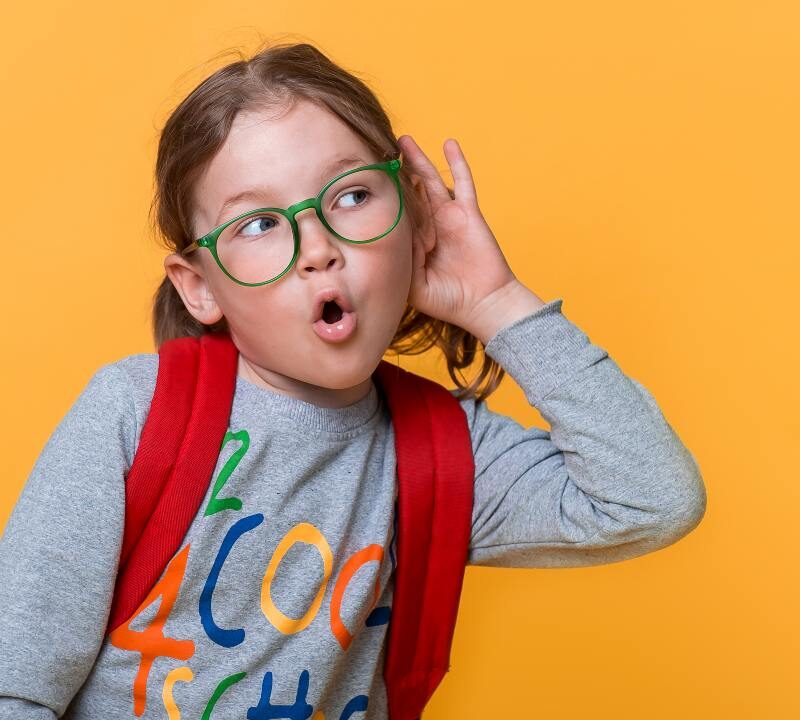 Niño con problemas de audición en clase siendo atendido por un especialista