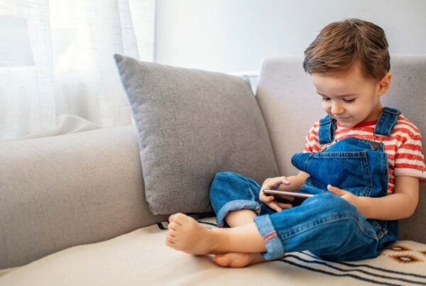 Niño usando una tableta junto a su madre, promoviendo el uso responsable de pantallas.