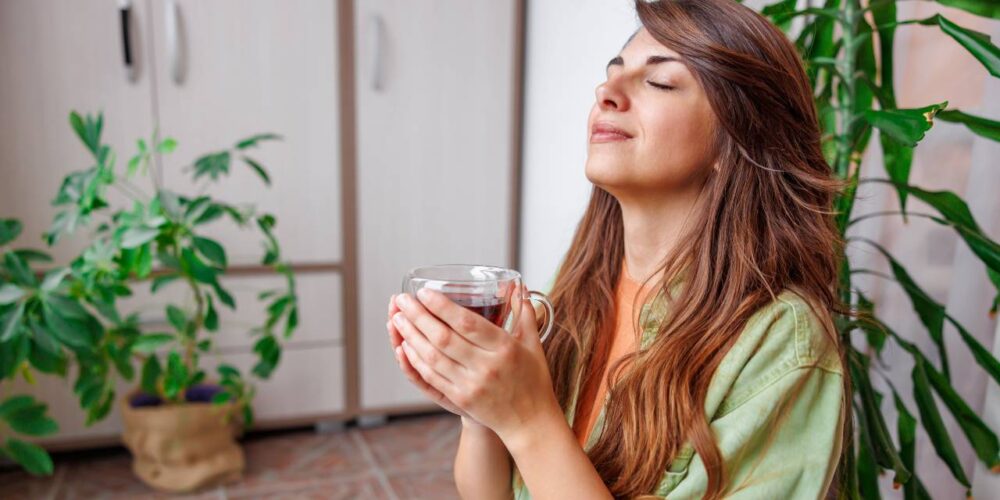 Taza de té verde con hojas frescas en un ambiente relajante.