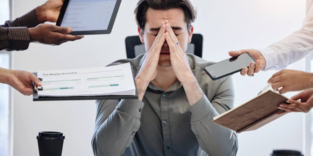 Persona rodeada de pantallas, atrapada por la trampa del multitasking