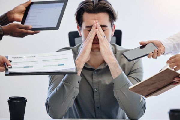 Persona rodeada de pantallas, atrapada por la trampa del multitasking