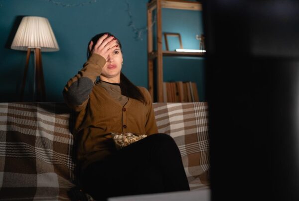 Persona estresada frente a la televisión con noticias negativas