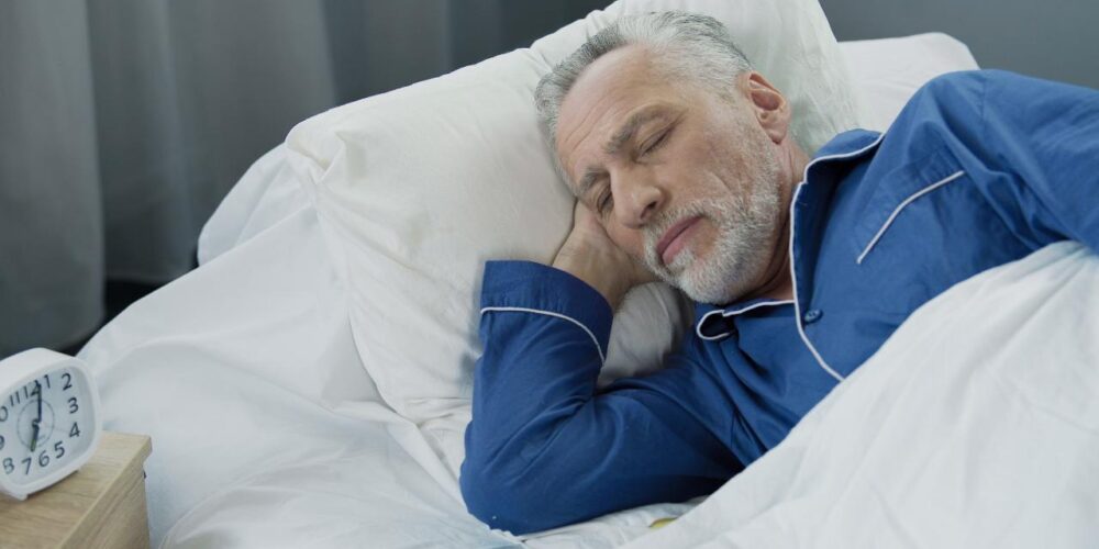persona mayor durmiendo plácidamente gracias a la higiene del sueño