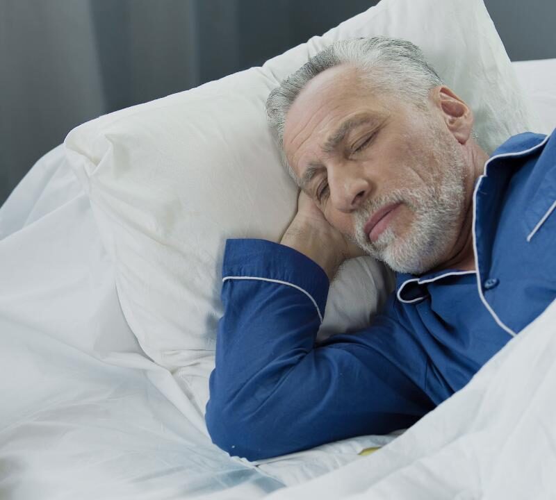 persona mayor durmiendo plácidamente gracias a la higiene del sueño