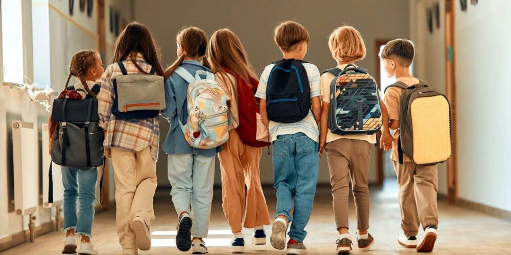 Niños con mochila escolar ergonómica correctamente colocada