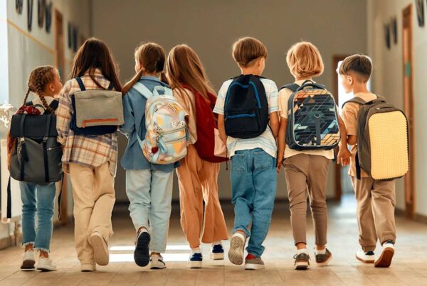 Niños con mochila escolar ergonómica correctamente colocada