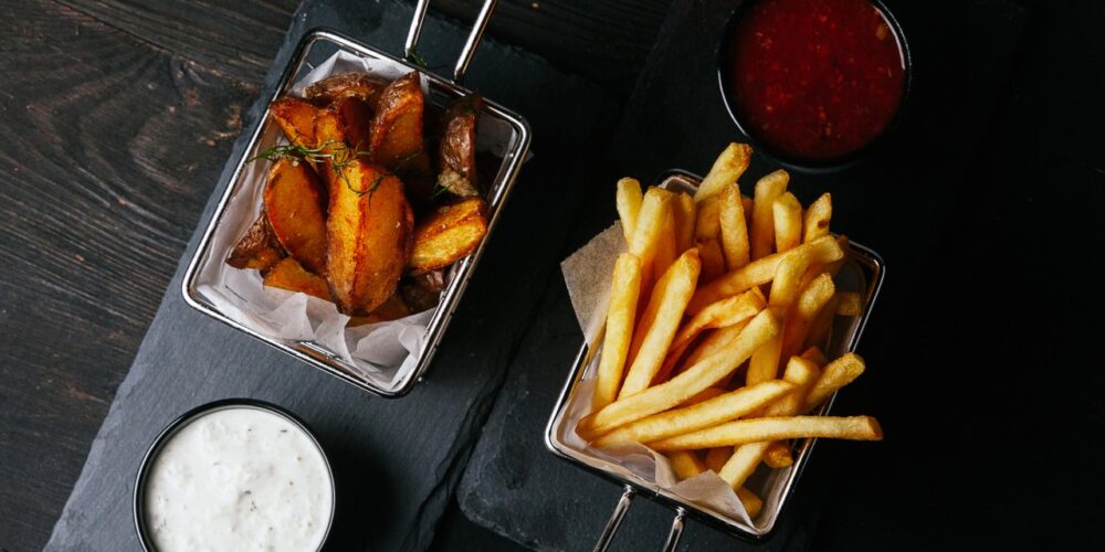 Papas fritas servidas en bandeja con fondo oscuro