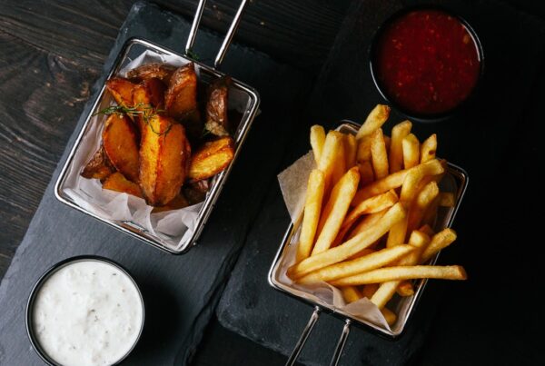 Papas fritas servidas en bandeja con fondo oscuro