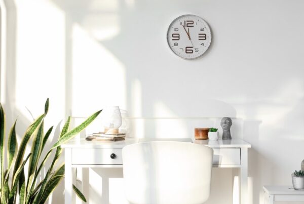 Reloj de pared con luz natural simbolizando los beneficios de no cambiar la hora.