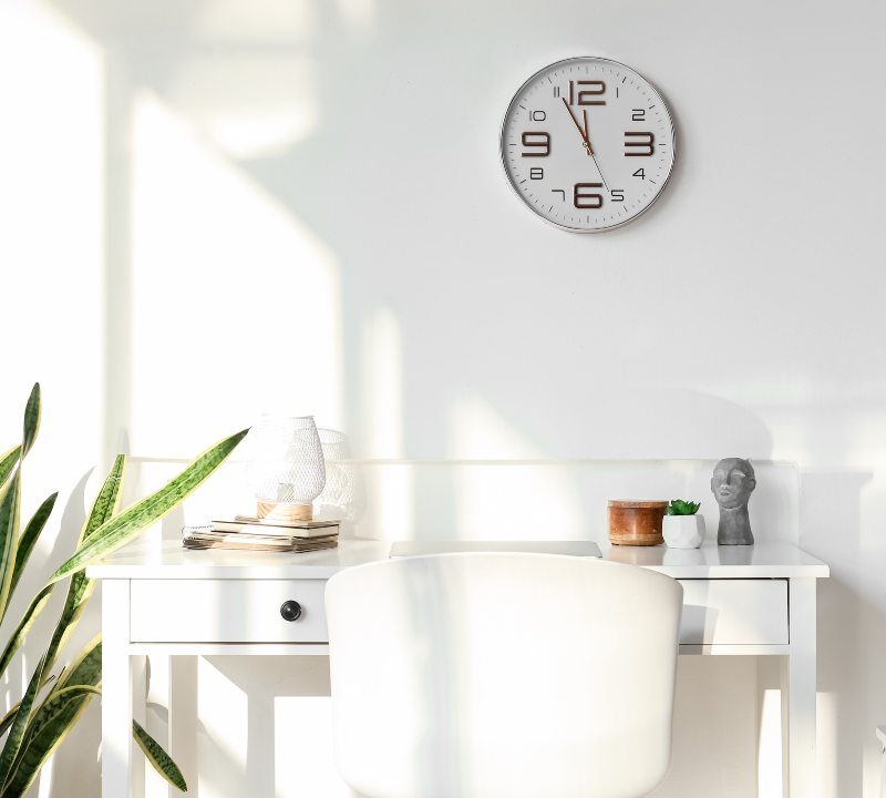 Reloj de pared con luz natural simbolizando los beneficios de no cambiar la hora.