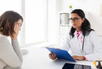 Médico explicando nuevos tratamientos para el cáncer de mama avanzado a una paciente.