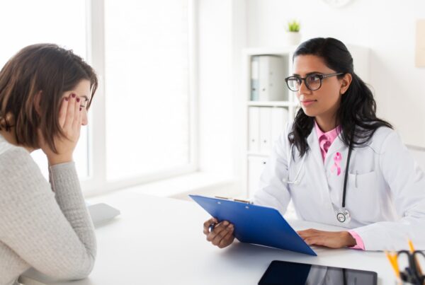 Médico explicando nuevos tratamientos para el cáncer de mama avanzado a una paciente.