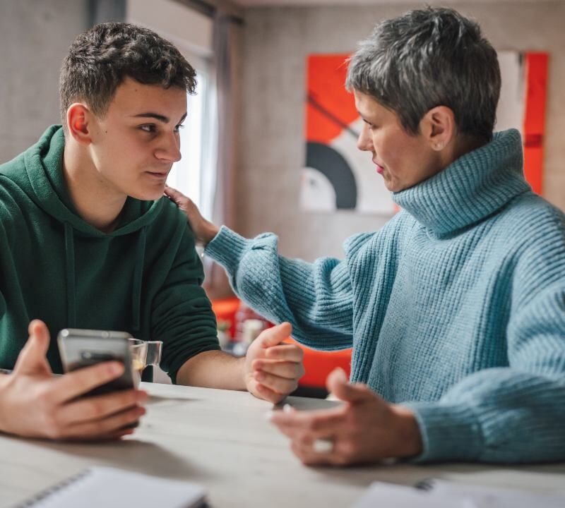 Padres conversando con su adolescente en un ambiente tranquilo y cercano.