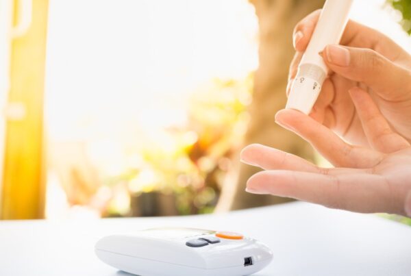 Persona revisando su nivel de azúcar en la sangre con un glucómetro, representando el control de la diabetes.