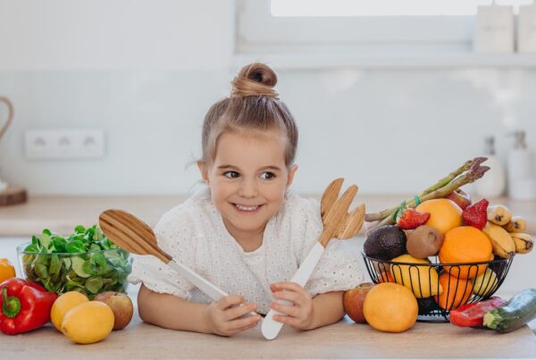 Niños comiendo variedad de frutas y verduras representando dietas vegetarianas y veganas