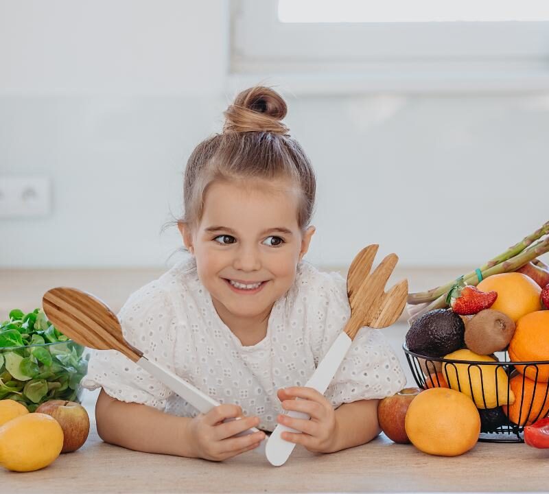 Niños comiendo variedad de frutas y verduras representando dietas vegetarianas y veganas
