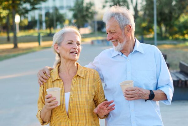 Pareja mayor caminando junta al aire libre y conversando