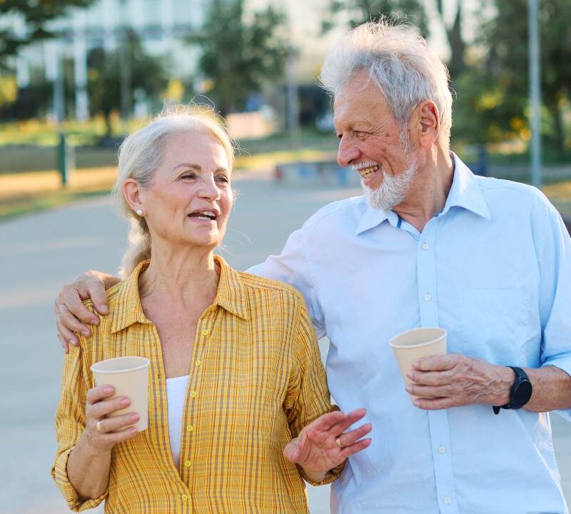 Pareja mayor caminando junta al aire libre y conversando