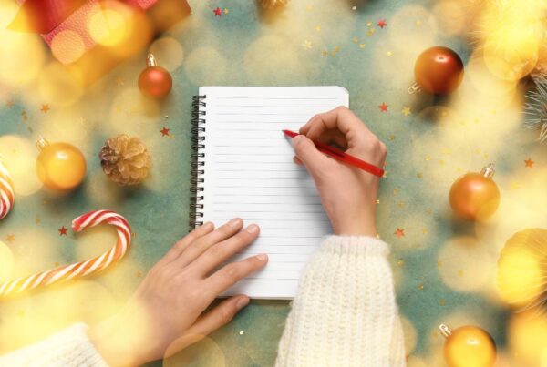 Persona planificando propósitos de Año Nuevo en una libreta
