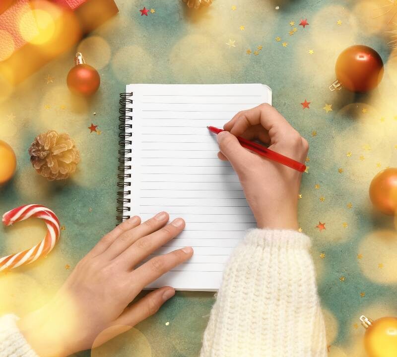 Persona planificando propósitos de Año Nuevo en una libreta