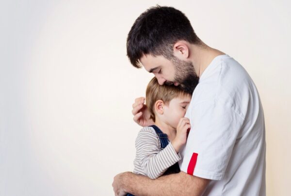 Adulto abrazando a su hijo como símbolo de sanar el pasado mientras crías