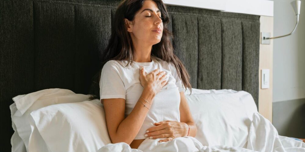 Mujer practicando ejercicios respiratorios para aliviar tos y flemas