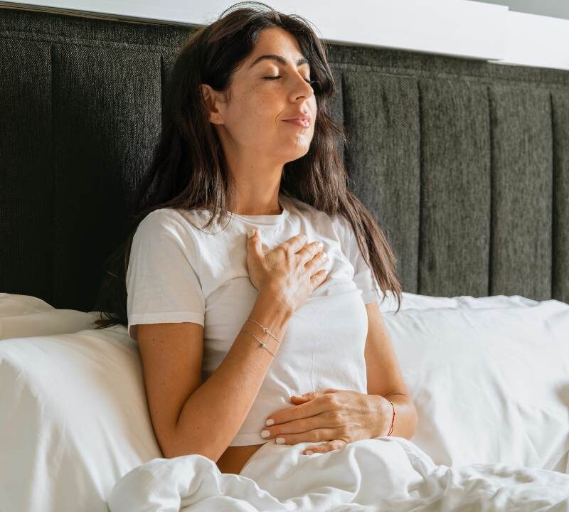 Mujer practicando ejercicios respiratorios para aliviar tos y flemas
