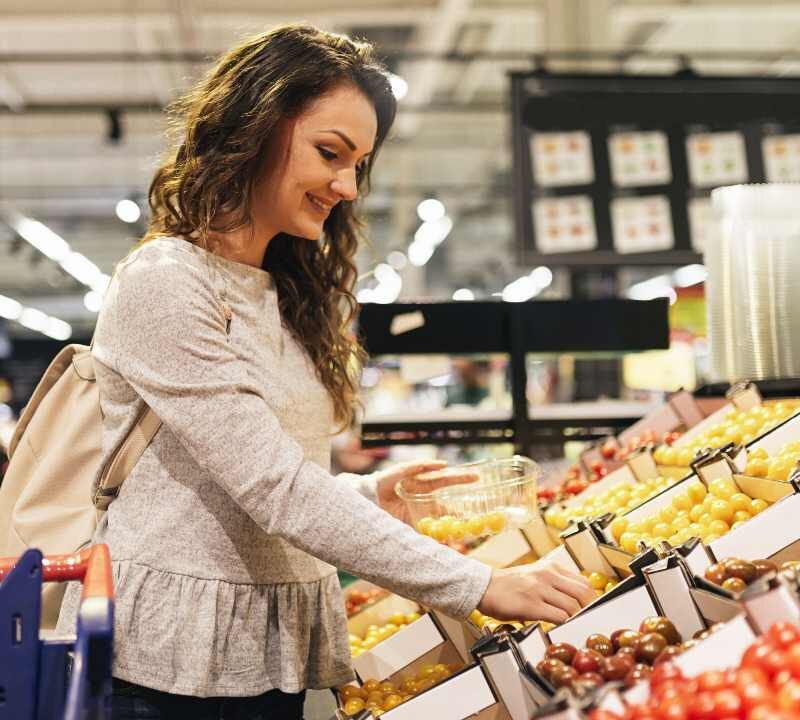 Persona eligiendo frutas y verduras en el supermercado tras usar medicamentos GLP-1