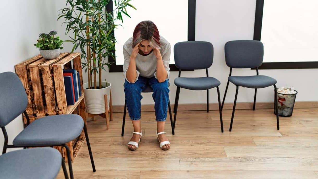 Persona reflexiva en consulta médica durante la espera de diagnóstico de una enfermedad rara