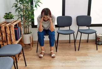 Persona reflexiva en consulta médica durante la espera de diagnóstico de una enfermedad rara