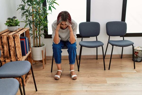 Persona reflexiva en consulta médica durante la espera de diagnóstico de una enfermedad rara