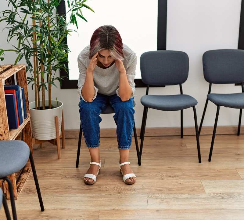 Persona reflexiva en consulta médica durante la espera de diagnóstico de una enfermedad rara