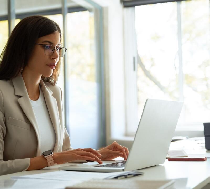 Persona trabajando en la oficina cuidando su postura para proteger huesos y articulaciones
