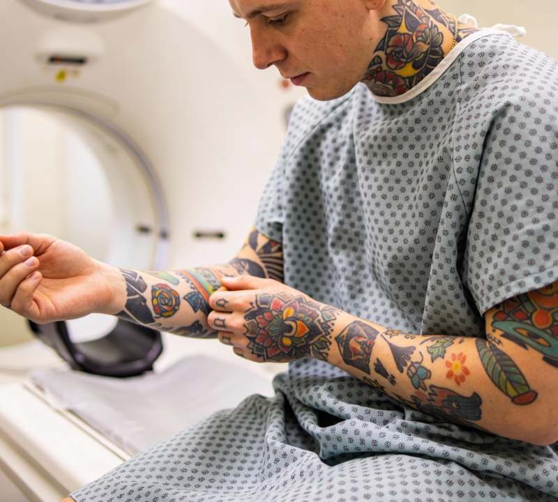 Paciente con tatuajes preparándose para un MRI