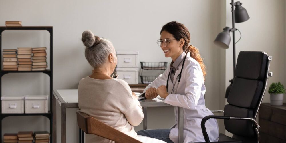 Médico realizando una evaluación neuropsicológica a una persona mayor para detectar signos de la enfermedad de Alzheimer.