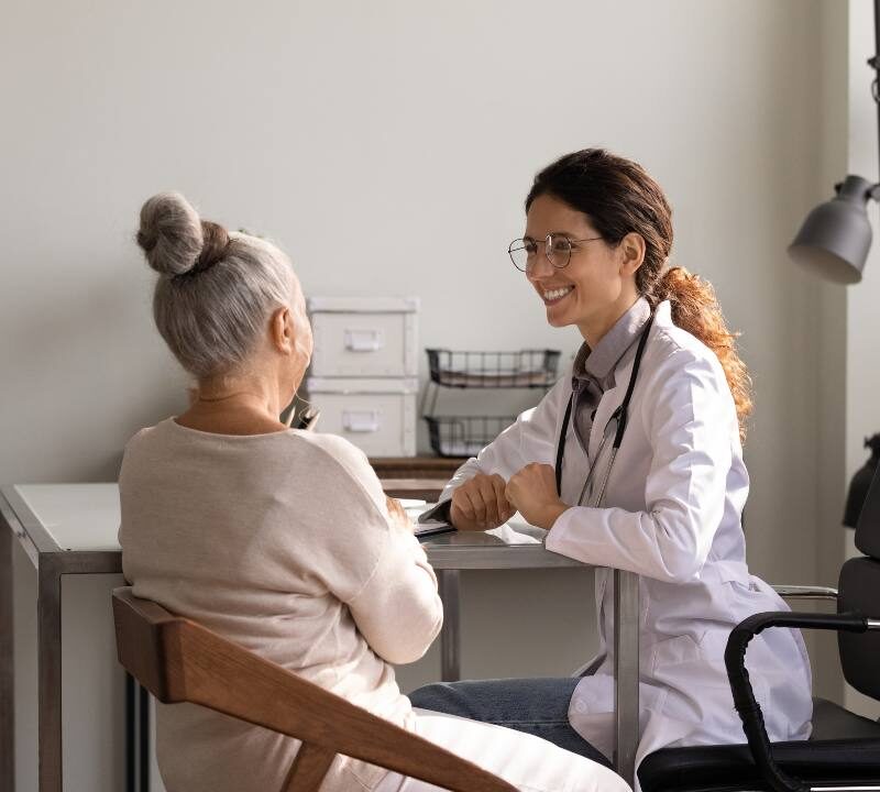 Médico realizando una evaluación neuropsicológica a una persona mayor para detectar signos de la enfermedad de Alzheimer.