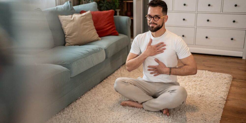 Persona realizando ejercicios de respiración para aliviar tos y flemas en casa.