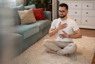 Persona realizando ejercicios de respiración para aliviar tos y flemas en casa.