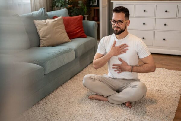 Persona realizando ejercicios de respiración para aliviar tos y flemas en casa.