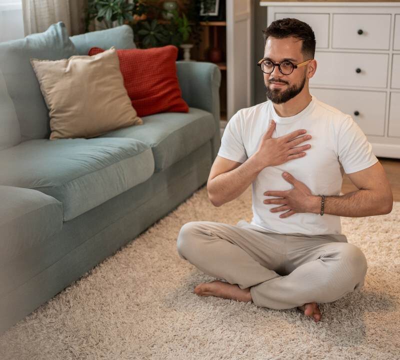 Persona realizando ejercicios de respiración para aliviar tos y flemas en casa.