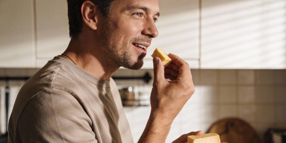 Persona comiendo porción de queso, asociado a salud cerebral y demencia
