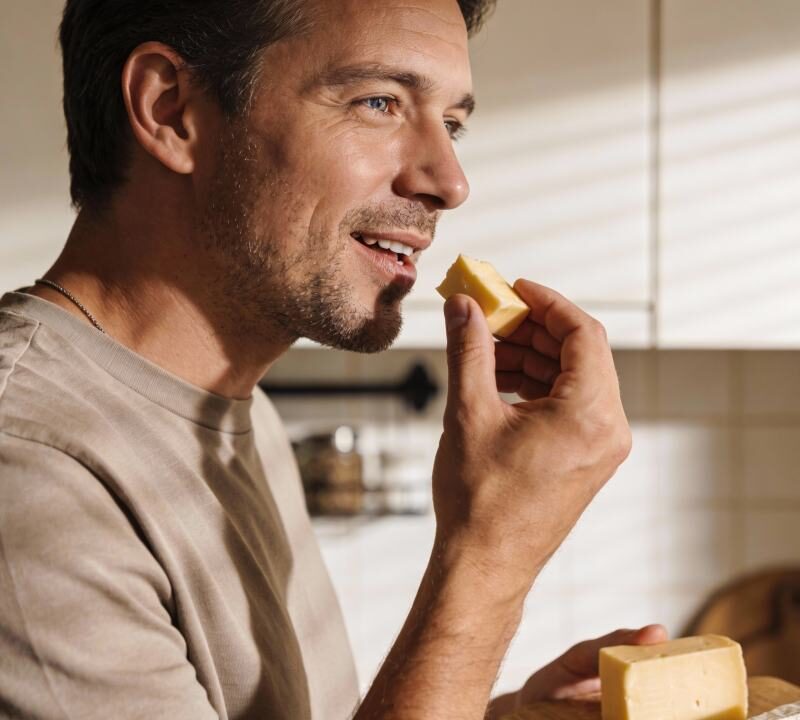 Persona comiendo porción de queso, asociado a salud cerebral y demencia