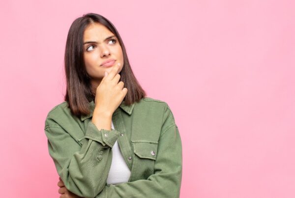 Mujer joven pensativa representando la salud hormonal y la prevención del cáncer.