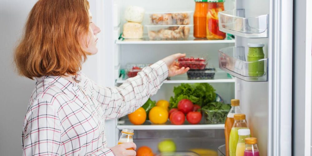 Persona organizando refrigerador para conservar bien los alimentos de forma segura