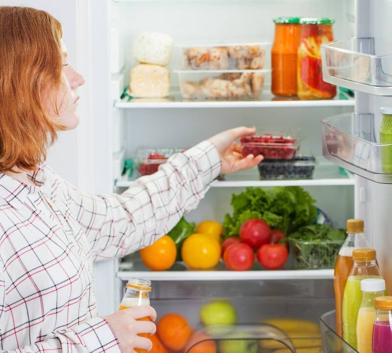 Persona organizando refrigerador para conservar bien los alimentos de forma segura