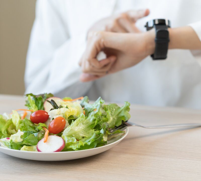 Persona mirando el reloj durante una dieta de ayuno intermitente