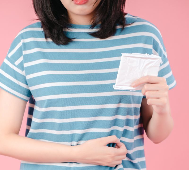 mujer sostiene compresa sanitaria como símbolo del test de papiloma en sangre menstrual