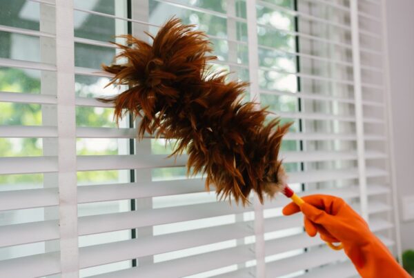 Persona limpiando el polvo y ventilando una habitación para mejorar la calidad del aire en casa