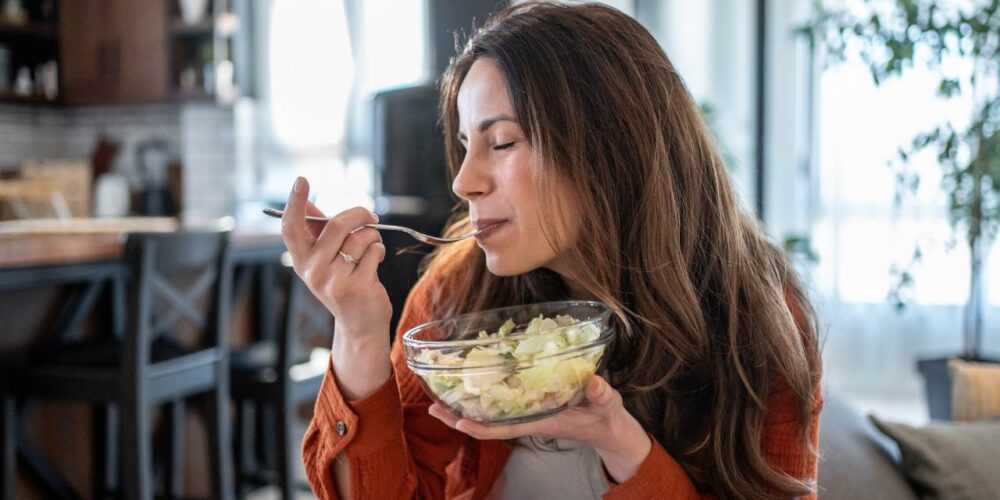 Persona de 45 años comiendo ensalada saludable rica en verduras para aumentar la longevidad